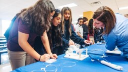 Mentor aiding in STEM activities with your girls