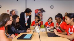 Girls on a table working on STEM project with mentors